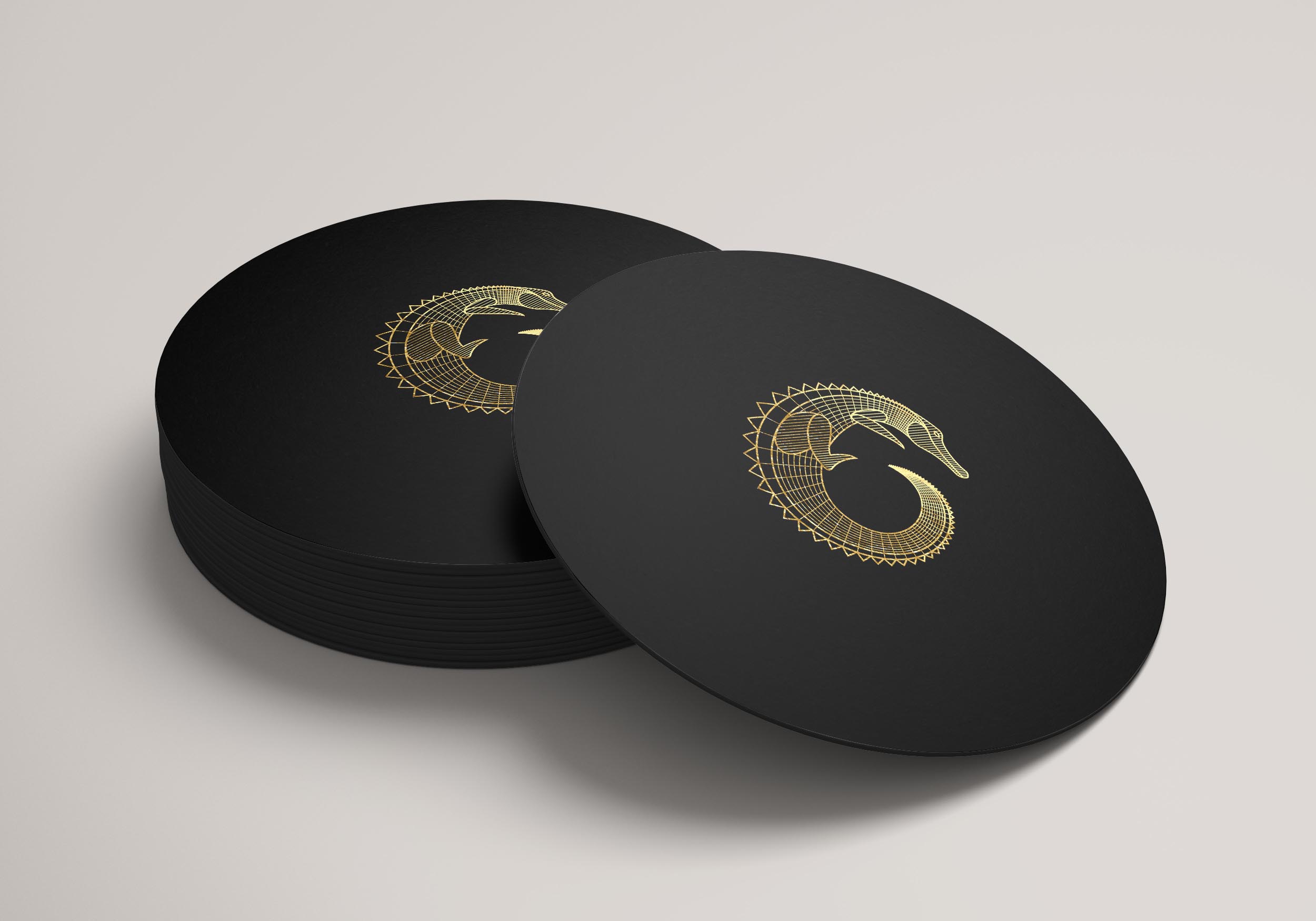 Black Coaster branded with a gold Golden Gator Amulet Logo