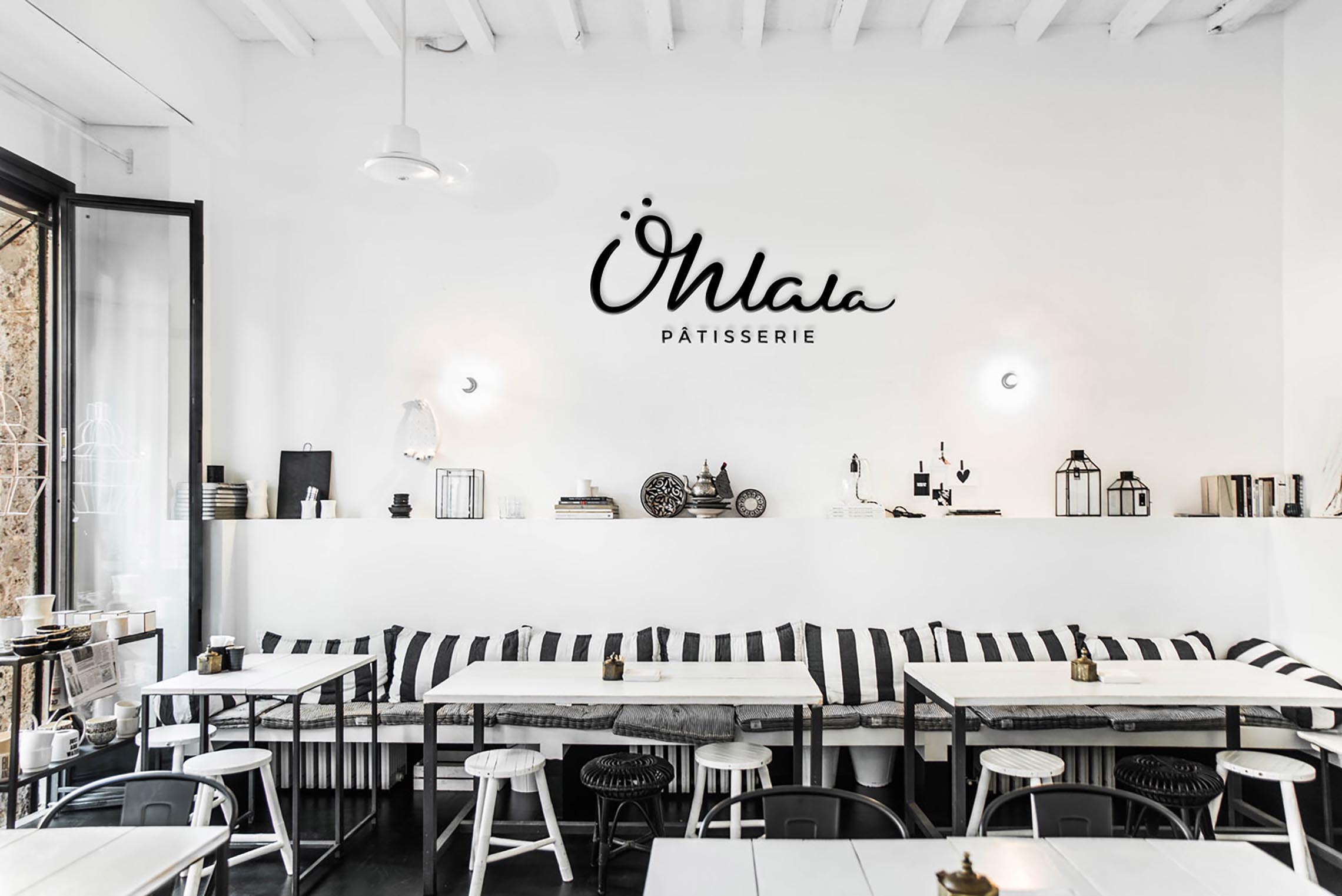 Lounge room with black and white striped sofa along tables and the Ohlala Logo on the back wall